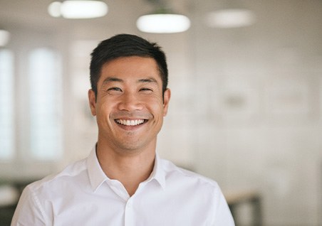 Man in white button-up shirt smiling
