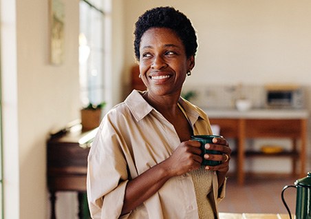 Smiling woman enjoying coffee at home