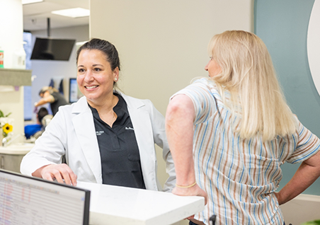 Dental team member showing a pamphlet to two patients