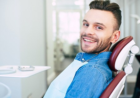 Patient smiling while sitting in dentist treatment chair