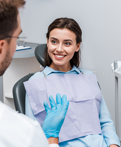 Woman in dental chair listening to her dentist talk about E 4 D same day dental crowns in Bellaire