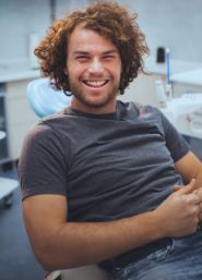 Young man grinning while sitting in dental chair