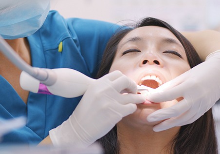 A woman getting scaling and root planing treatment
