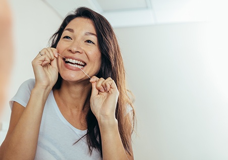Woman smiling while flossing