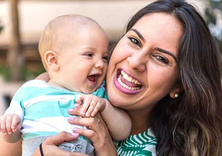 Woman holding her laughing baby