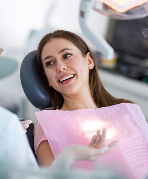 Woman in dental chair listening to her dentist talk about restorative dentistry in Bellaire
