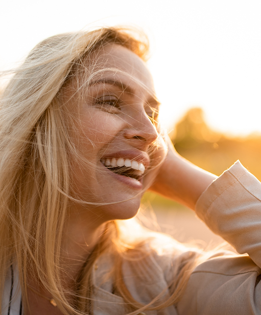 Blonde woman smiling outdoors on a sunny day