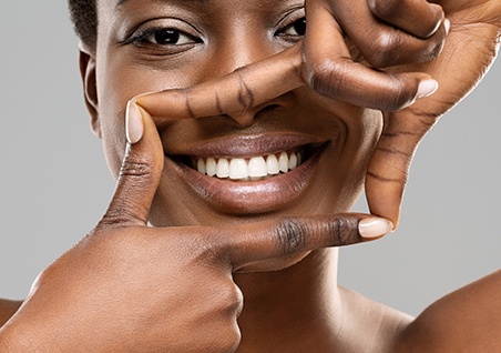 Woman framing her smile with her hands